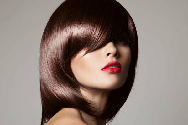 A girl with a haircut and makeup on a neutral background