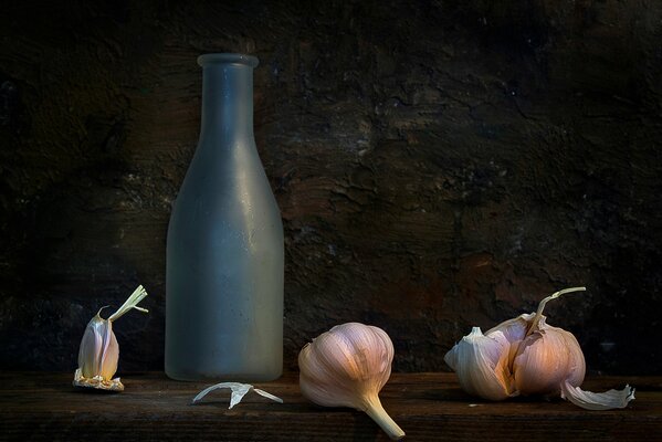 A composition of garlic and a bottle on a dark background that s where I m bad for you