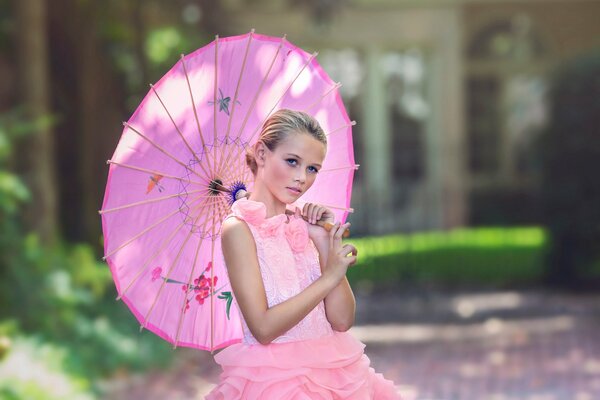 Ragazza in abito rosa e con ombrello