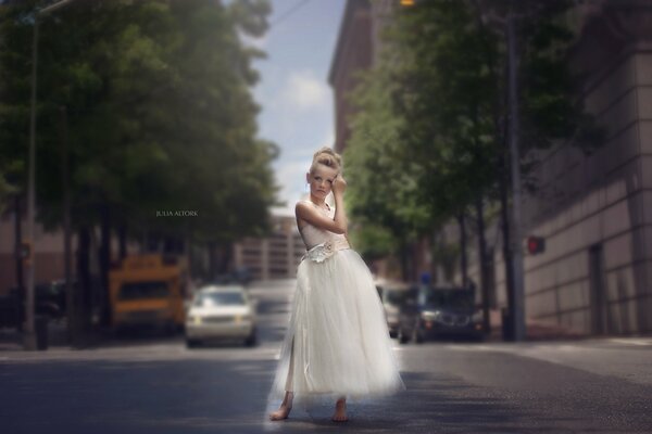 A girl in a white dress on a city street