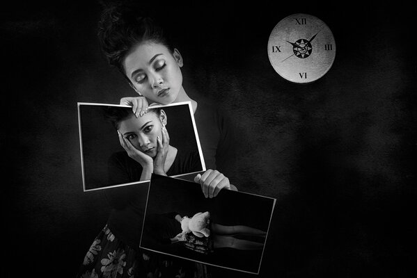 A girl on the background of a clock holding her photos in her hands