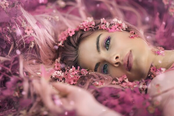 Schönes Mädchen liegt in Blumen