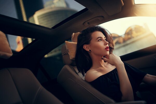 Une fille dans une voiture avec un regard réfléchi