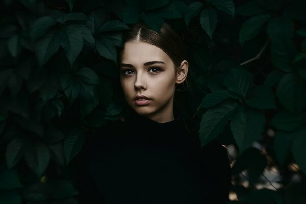 The girl in the portrait photo next to the leaves