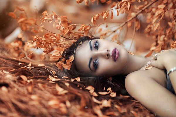 Fille avec beau maquillage et autour des feuilles