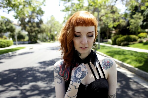 Justine Marie with tattoos on her body on the background of the road