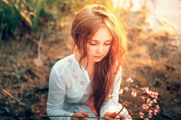 Fille avec des fleurs sur fond de soleil