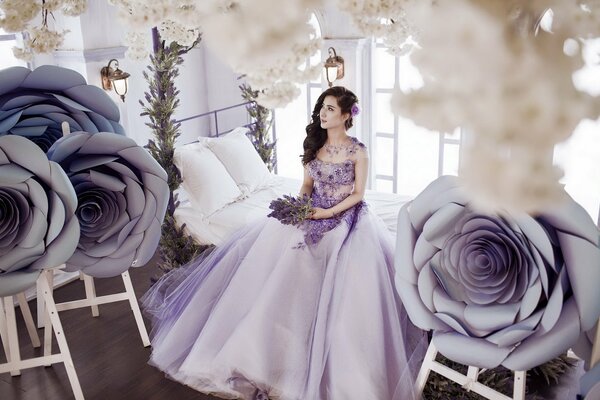 Ragazza in abito color lavanda sul letto