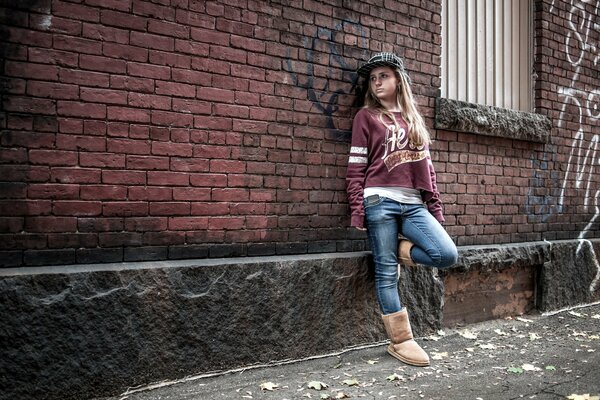 Chica de estilo urbano junto a una pared de ladrillo