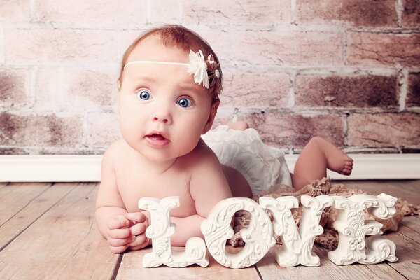 Cute newborn baby girl lying on the floor