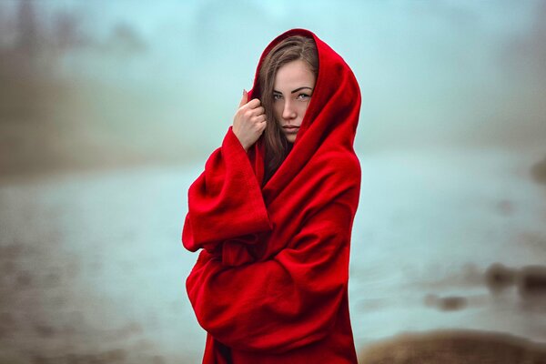 Hermosa chica en rojo tippet en la niebla