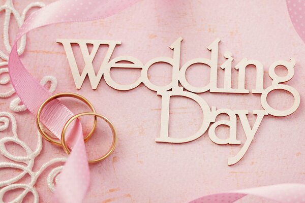 Two wedding rings on a pink background