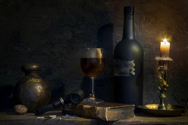 Still life with a glass a candle bottle and a pipe