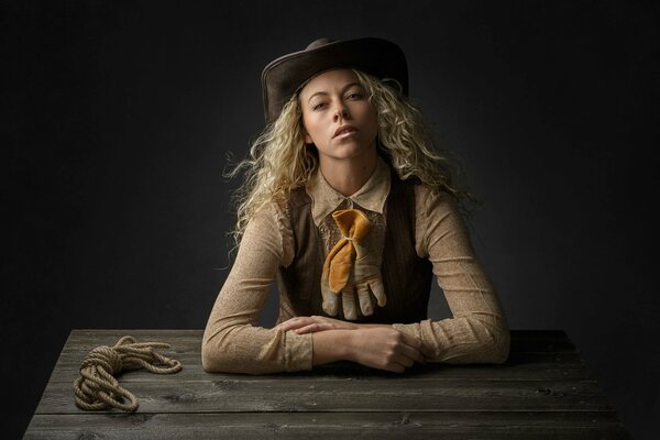 Fille blonde dans un chapeau de cow-Boy à la table