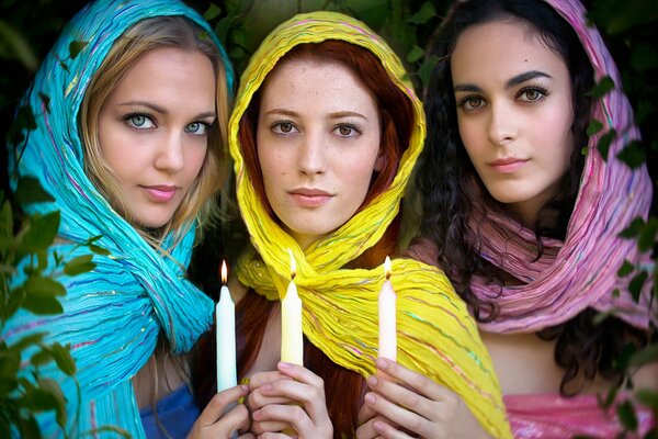 Three girls with lighted candles in their hands