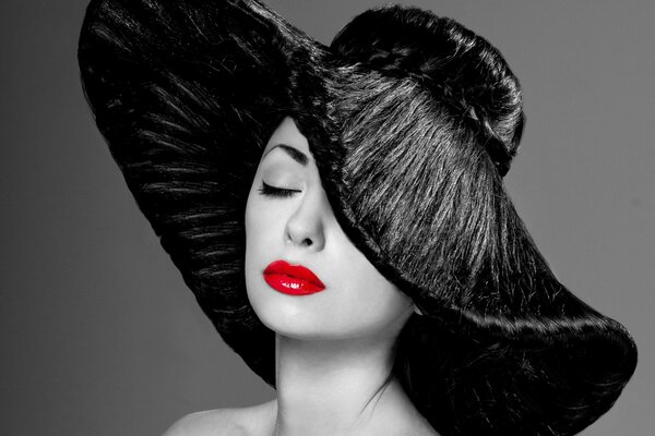 Femme chic avec un chapeau noir et rouge à lèvres rouge