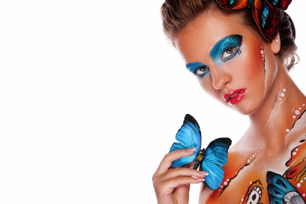 Butterfly-style body art with makeup and an open-eyed look