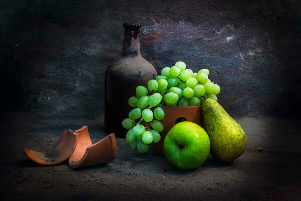 Frutas y una botella antigua sobre un fondo oscuro