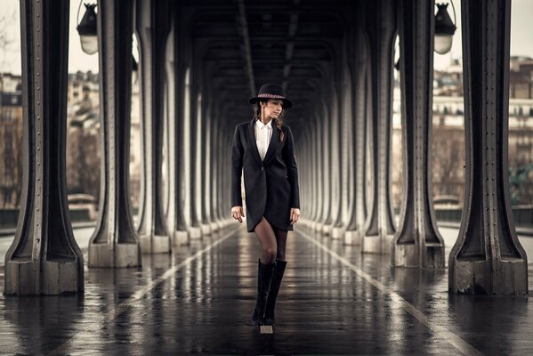 La jeune fille au chapeau marche sur la place de la gare