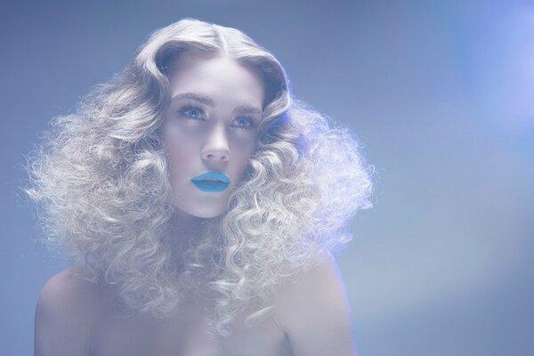 Fille blonde avec des boucles et rouge à lèvres bleu