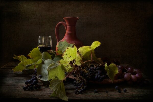 A jug drowning in grapes and its leaves