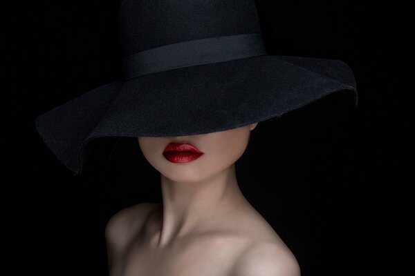 Retrato de una chica de sombrero negro con labios rojos