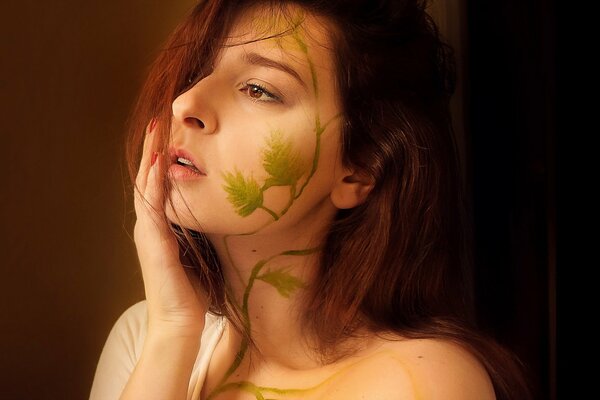 Fille de profil avec un motif sur le visage sous la forme d une plante grimpante