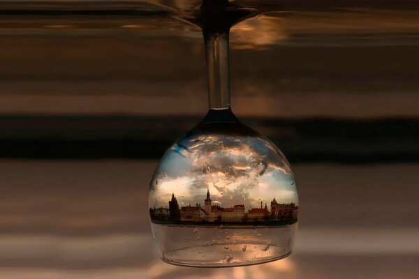 An inverted glass with a reflection of the city in it