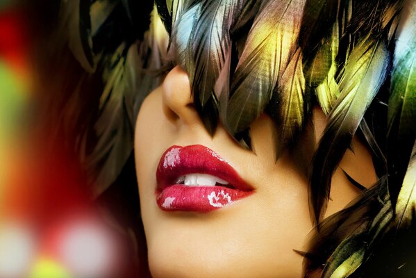 A girl s face covered with feathers from her hair., bright lipstick on her lips