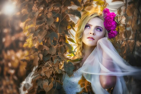 A beautiful girl in the foliage of a tree