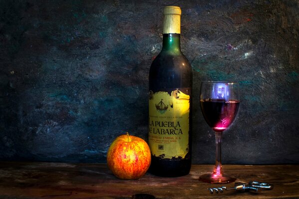 Una Copa de vino sobre la mesa y una manzana