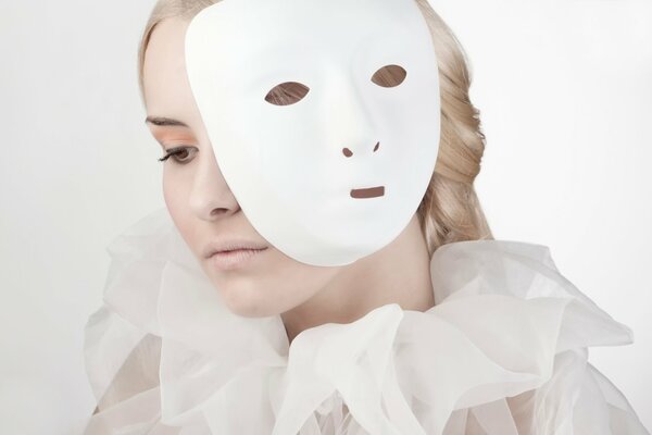 Photo of a blonde in white behind a mask