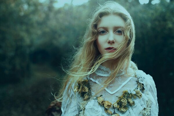 Blonde girl with dry flowers on her cleavage