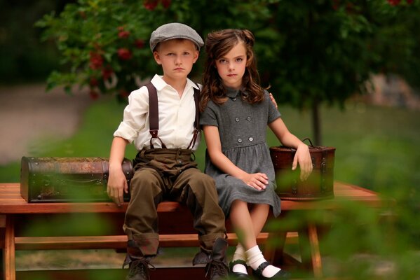 Mädchen und Jungen sitzen auf einer Bank