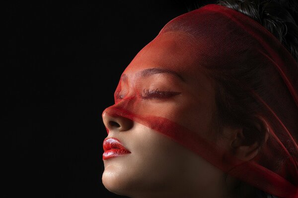 A girl hidden by a red veil