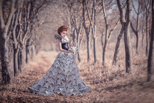 Chica en un vestido de periódico en el Jardín