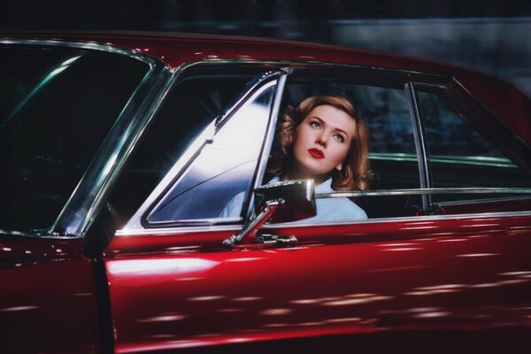 Red-haired beauty in a red car