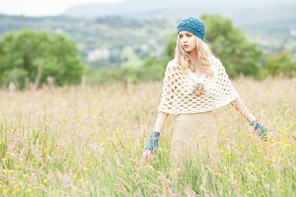 Chica de moda en el campo con un vestido y una boina de punto en la cabeza