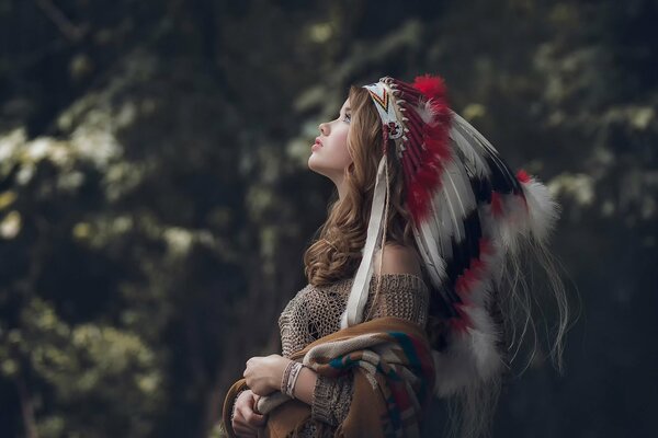 A girl in profile with feathers on her head