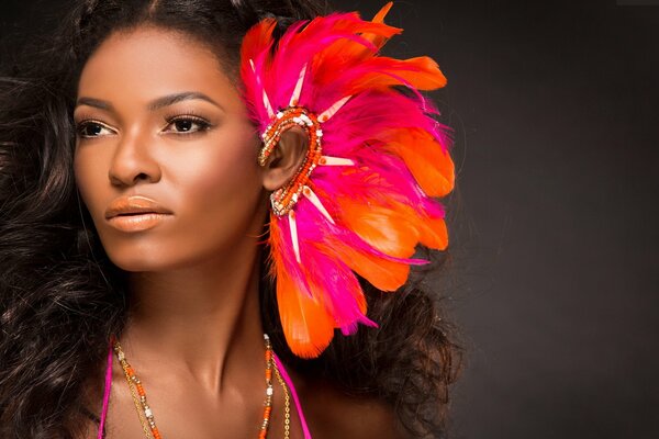 Curly-haired dark-skinned girl with a feather decoration on her ear