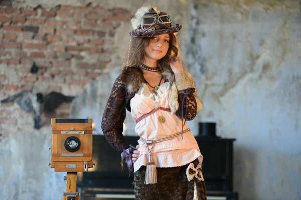 A girl in vintage clothes next to an antique camera