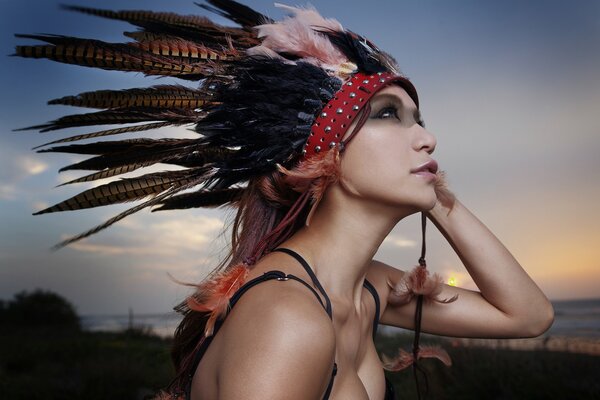 Chica con plumas en el fondo de la naturaleza