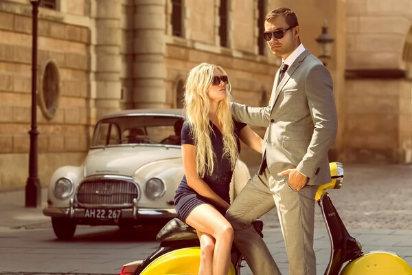 Summer in Copenhagen, a couple in fashionable outfits with a yellow moped and a vintage car