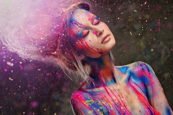 A girl with closed eyes in the colors of Holi