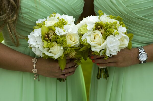 Dos chicas en vestidos verdosos idénticos y con Ramos de flores