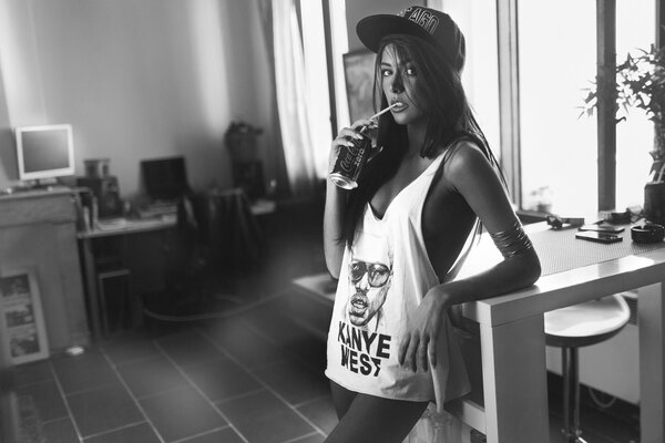 A girl in a T-shirt and a baseball cap with a coke