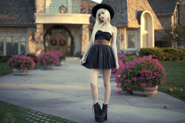 Chica con vestido negro posando en el fondo de la casa