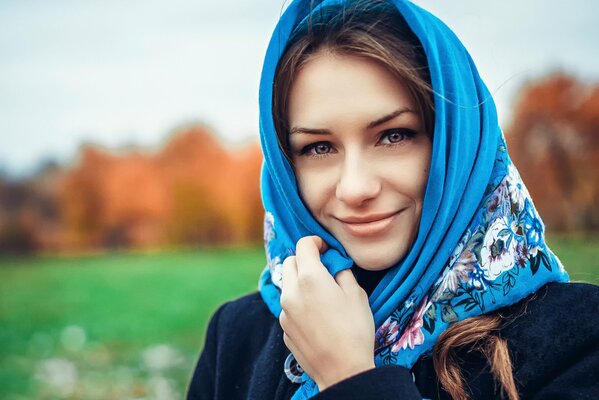 Belleza rusa de ojos marrones en un pañuelo azul