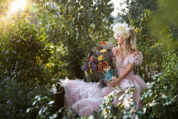 Mädchen sitzt in der Natur mit Blumen