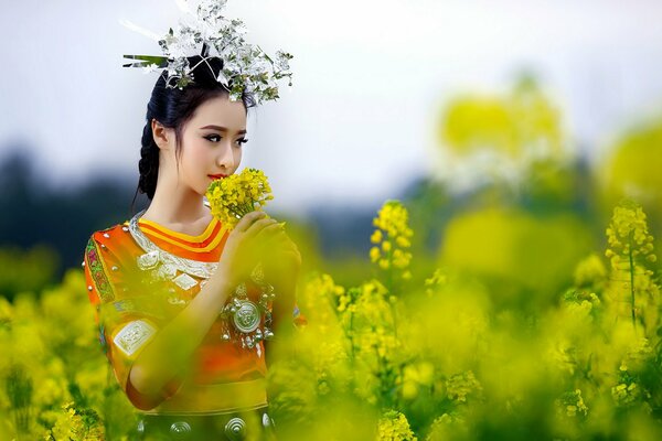 Asian woman walks in a field of flowers